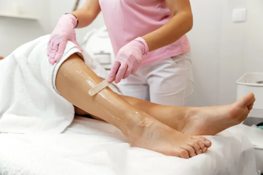 Profissional de estética a aplicar depilação.